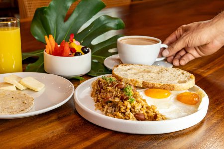 Foto de Desayuno colombiano con arepas, café, pan, huevos, arroz caliente y fruta - Imagen libre de derechos
