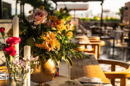 Téléchargez les photos : Beau et élégant cadre de table sur un toit de l'hôtel. Fleurs, vue et élégance. - en image libre de droit