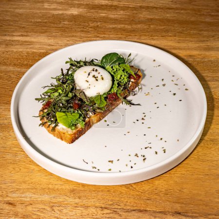 Französischer Toast mit Salat und pochiertem Ei, Gourmet-Hotelrestaurant. Holztisch.
