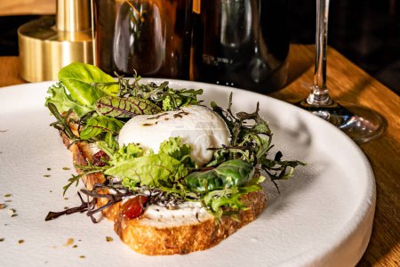 Französischer Toast mit Salat und pochiertem Ei, Gourmet-Hotelrestaurant. Holztisch.