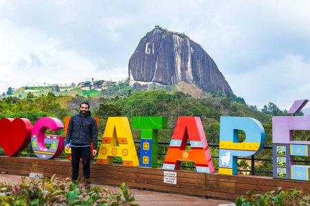 Hombre latino viajando y visitando un pueblo muy popular en Colombia. Guatape piedra gigante. Paisajes y vacaciones.