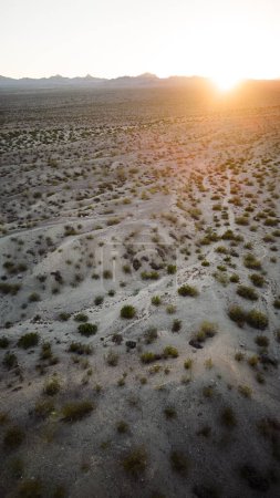 Photo for Vertical view of sand and desert with mountains from aerial view drone shot of lake mohave in the national recreation area of lake mead in nevada and arizona with the sun setting showing six mile cove and its sand - Royalty Free Image
