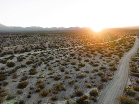 Photo for Horizontal view of sand and desert with mountains and sunset from aerial view drone shot of lake mohave in the national recreation area of lake mead in nevada and arizona with the sun setting showing six mile cove and its sand - Royalty Free Image