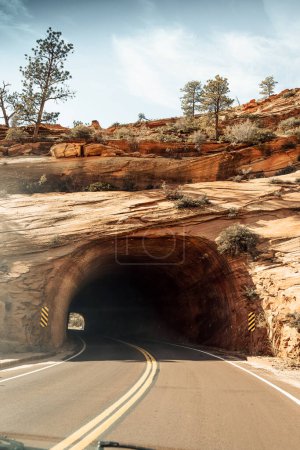 Téléchargez les photos : Tunnel sur une route principale menant au parc national de Sion Etats-Unis avec de belles couleurs et un ciel bleu pour l'espace de copie. États-Unis sud-ouest. - en image libre de droit