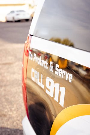 Téléchargez les photos : Image verticale de l'arrière d'un véhicule de police lisant Protéger et servir l'appel 911 - en image libre de droit
