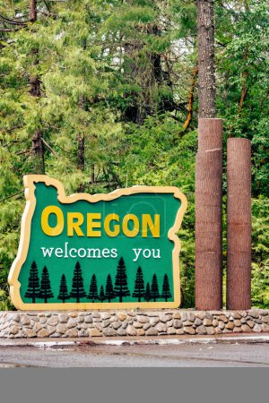 Photo for Vertical image of Oregon welcomes you sign on Redwood Highway with puddle after rain. - Royalty Free Image