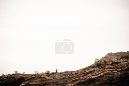 Téléchargez les photos : 40s randonneur masculin sur le rebord bénéficie de la solitude au-dessus de Boynton Canyon Sedona - en image libre de droit