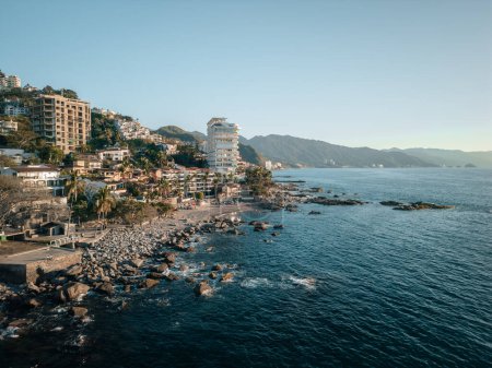 Aerial view of Conchas Chinas Beach and hotels in Puerto Vallarta Mexico in late afternoon.