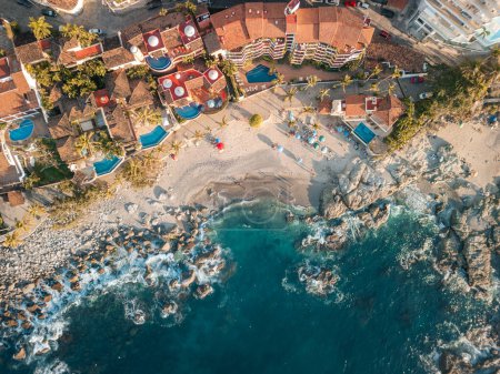 Amplia vista aérea de la playa de Conchas Chinas en Puerto Vallarta México. Villas, olas, aguas turquesas.