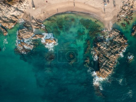 Horizontal aerial view of Conchas Chinas Beach in Puerto Vallarta. Bright clear turquoise water at beach.