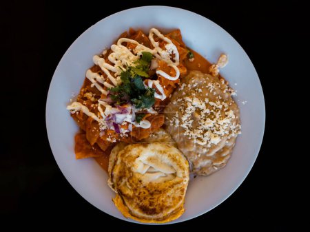 Traditional chilaquiles mexican food for breakfast in Mexico. Top down view on table flat lay.