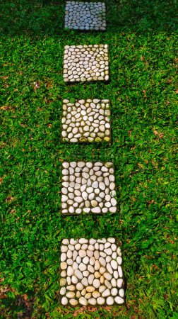 Téléchargez les photos : Pied carré chemin utilisé sur l'herbe à la maison jardin ou parc. - en image libre de droit