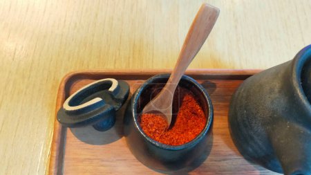 Foto de Polvo de chile en una taza de cerámica, por lo general siempre se puede encontrar en la mesa de comedor del restaurante asiático - Imagen libre de derechos