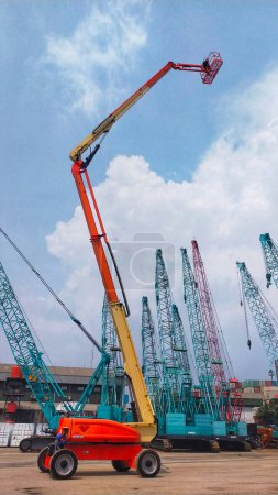 Téléchargez les photos : Jakarta, Indonésie - 22 juin 2022 : Ascenseur à flèche 38 mètres JLG 1250 AJP type articulé travaillant sur flèche vers le haut à la cour. - en image libre de droit