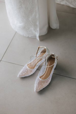 Beautiful detail close up white woman wedding shoes at the floor.