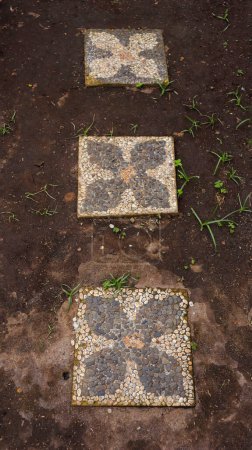 Téléchargez les photos : Chemin de pierre de forme carrée posé sur l'herbe au jardin ou au parc. - en image libre de droit