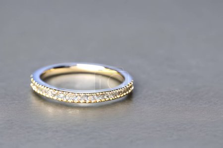 Foto de Impresionante primer plano de un solo anillo de bodas, delicadamente entrelazado para simbolizar el vínculo eterno de amor y compromiso. Anillo de diamantes de oro para aniversario, San Valentín o compromiso - Imagen libre de derechos