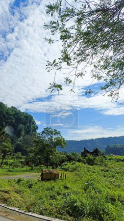 Natur Landschaft traditionelles Minangkabau Haus umgeben von schönen grünen Hügeln und strahlend blauem Himmel