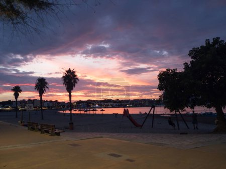 Téléchargez les photos : Coucher de soleil sur la plage avec paysage nuageux multicolore - en image libre de droit