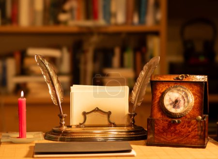 Téléchargez les photos : Bureau vintage classique avec une bougie rouge et une horloge antique - en image libre de droit