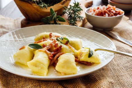 Photo for Stuffed gnocchi seasoned with melted butter, sage and strips of speck - Royalty Free Image