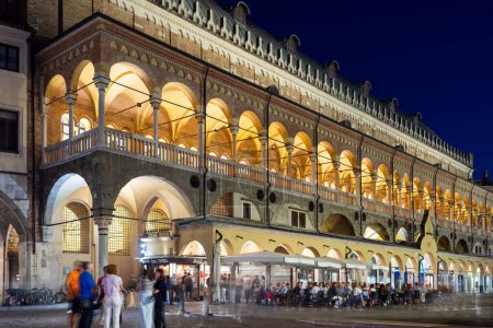 Foto de Padua, Italia - 1 de octubre de 2023: Palazzo della Ragione por la noche con gente en la plaza de abajo - Imagen libre de derechos