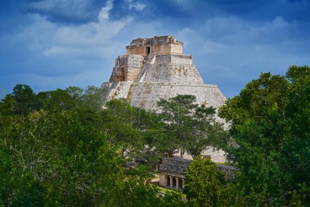 Téléchargez les photos : Uxmal ruin Mexico, Pyramid of the Magician in the green tropic forest with dark storm clouds. Piramide Adivino in Uxmal, Maya ruins in Yucatan, Mexico. Travel in Central America. - en image libre de droit