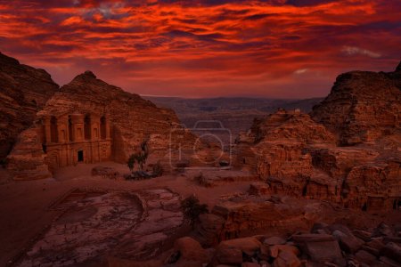 Photo for Stone Monastery in rock, Petra in Jordan. Red rock landcape. Petra historical sight - Ad Deir Monastery with full moon during the night. Evening light in nature. Travel in Jordan, Arabia in Asia. - Royalty Free Image