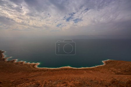 Foto de Mar muerto, paisaje desde Jordania. Costa, agua con cielo azul con nubes. lago salado bordeado por Jordania al este y Cisjordania e Israel al oeste. - Imagen libre de derechos