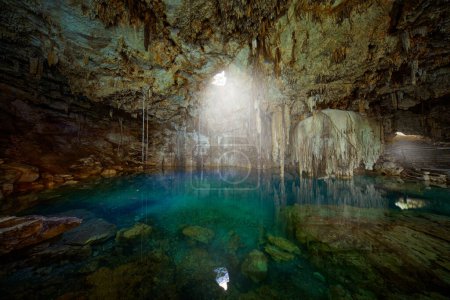 Photo for Cenote Dzitnup Xkeken, cave south of Valladolid. Landscape in Yucatan, Mexico. Green blue water lake in cave, light in the hole. Travel in Mexico. - Royalty Free Image