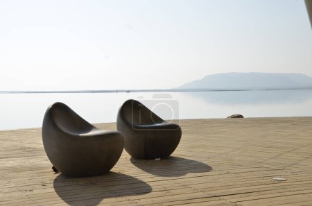 Téléchargez les photos : Paysage de la mer morte avec chaises de plage, ombre en forme de coeur - en image libre de droit