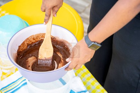 Foto de Primer plano de las manos vertiendo pudín con crema de chocolate en un plato blanco. - Imagen libre de derechos