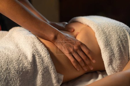 Mains massant l'estomac d'une femme. Le thérapeute appuie sur le ventre. Femme se faire masser dans un spa