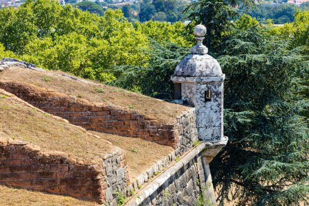 A section of the old Valenca Fortress wall with a white guard watchtower, green trees. Portuguese border with Spain through Galicia. Valenca, Portugal.