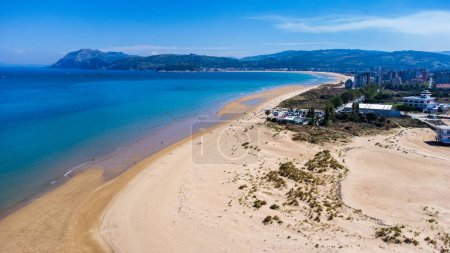 Aerial view of the sandy spit, La Salve beach, bay, and the city of Laredo, the waters of the Cantabrian Sea, and mountains in the distance. Laredo, Cantabria, Spain.
