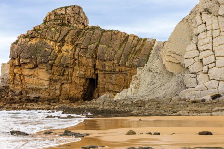 Playa Portio con su arena dorada, capas de roca erosionadas desde la Glaciación, y fascinantes formaciones rocosas erosivas y sedimentarias. Geoparque Costa Quebrada, Cantabria, España.