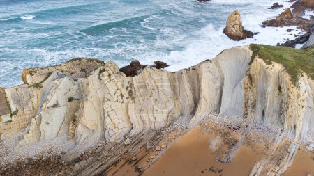 Vue aérienne de Portio Beach, falaises blanches nettes distinctives faites de rochers stratifiés et de l'océan Atlantique orageux. Géoparc de Costa Quebrada, Cantabrie, Espagne.