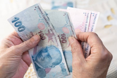 old women hands holding Turkish Lira banknotes