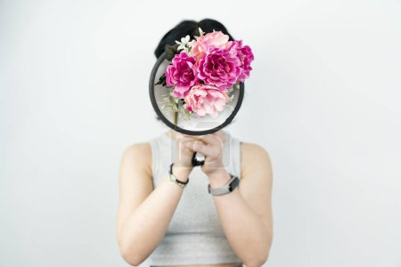 Foto de No seré silenciado. Foto de estudio de una mujer joven usando un megáfono sobre un fondo blanco. megáfono con flores dentro. - Imagen libre de derechos