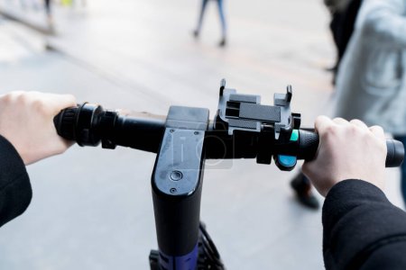 Téléchargez les photos : Scooter électrique équitation dans la ville, vue de perspective personnelle - en image libre de droit