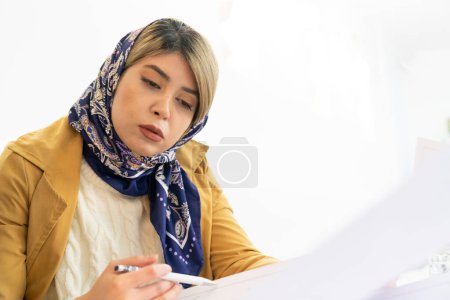 Téléchargez les photos : Portrait d'une femme d'affaires mulsime avec foulard dans un bureau moderne - en image libre de droit