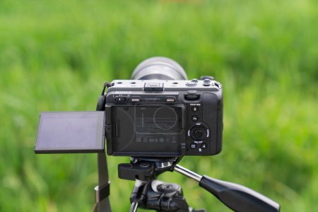 Foto de Cámara de vídeo profesional con un trípode en el fondo de la hierba - Imagen libre de derechos