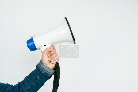 Téléchargez les photos : Jeune homme tenant un mégaphone tout en posant sur un fond blanc - en image libre de droit