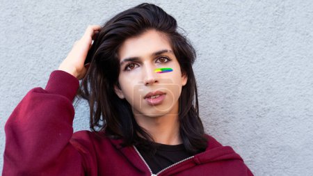 Photo for Portrait of a non-binary person posing for the camera with lgbt flag on cheek - Royalty Free Image