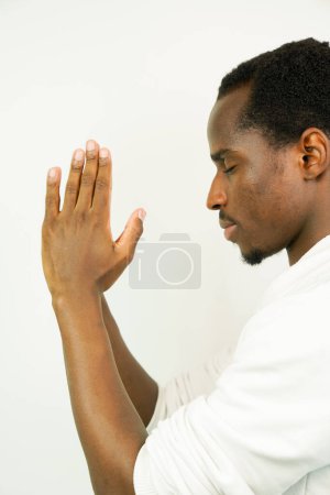 Foto de Joven hombre negro rezando, aislado sobre fondo blanco - Imagen libre de derechos