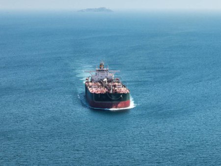 Foto de Vista superior aérea Contenedor buque contenedor de carga completa en el mar verde con hermoso patrón de olas para la logística, envío, exportación de importación o transporte. - Imagen libre de derechos