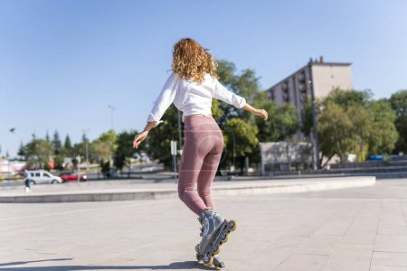 Foto de Mujer joven patinaje en línea en un parque - Imagen libre de derechos