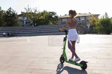 Photo for Woman riding e-scooter through the city - Royalty Free Image