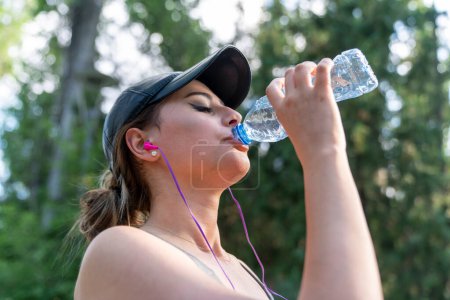 Photo for Woman drinking water after hard workout in the park. - Royalty Free Image