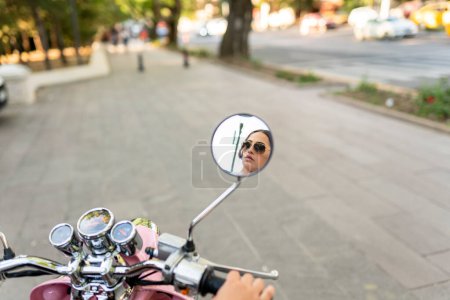Photo for Young Woman Riding Scooter In The City, back mirror view - Royalty Free Image